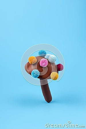 Colorful mushroom made of pom pom on blue background Stock Photo