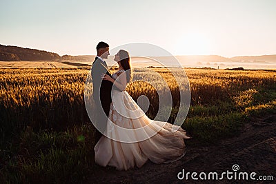 Colorful nature surrounds comely hugging wedding couple Stock Photo