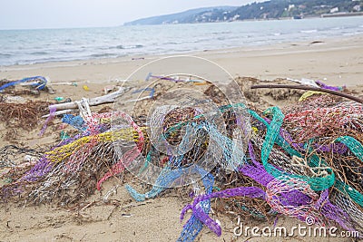 Colorful nets on beach. Trash in nature. Ecology crisis concept Stock Photo