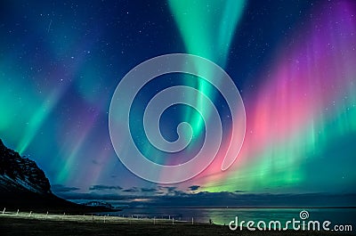Colorful northern lights spiral in a Iceland beach Stock Photo