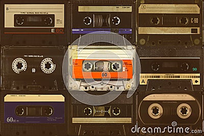 Colorful orange compact cassette in front of black audio tapes Stock Photo