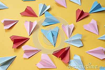 Colorful origami paper airplanes on yellow colored background Stock Photo