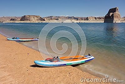 Colorful paddle boards pulled up on the sandy beach at Lake Powell Editorial Stock Photo