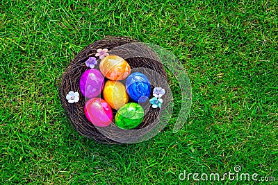 Colorful painted Easter eggs in nest on fresh green grass top view, Happy Easter Holliday concept background with copy Stock Photo