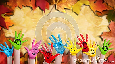 Colorful painted hands in front of many colored leafs Stock Photo