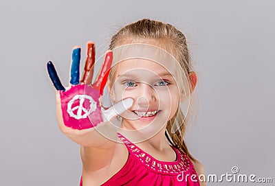 Colorful painted peace sign in a beautiful young girl. Stock Photo