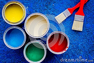 Colorful paints and brushes on blue wooden desk background top view Stock Photo