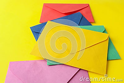 Colorful paper envelopes on yellow background. Mail service Stock Photo