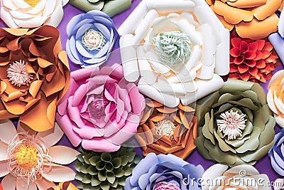 Colorful paper flowers on wall. Handmade artificial floral decoration. Spring abstract beautiful background and texture Stock Photo