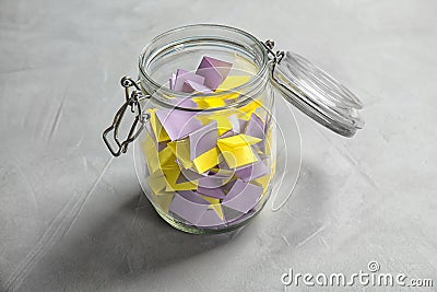 Colorful paper pieces for lottery in glass jar Stock Photo