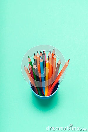 Colorful pencils in a cup on blue background top view Stock Photo