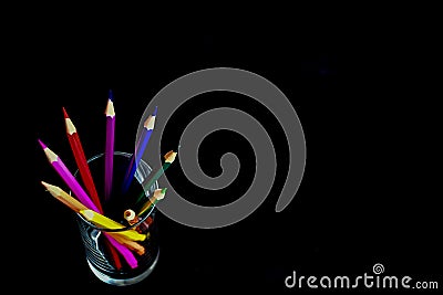 Colorful pencils in glass on Black ckground Stock Photo