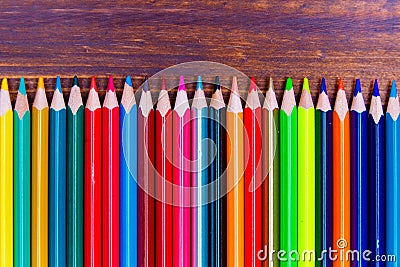 Colorful pencils lying on wooden board Stock Photo