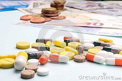 Colorful pills and capsules on background of dollar and euro banknotes. concept of high cost treatment, preservation of health and Stock Photo