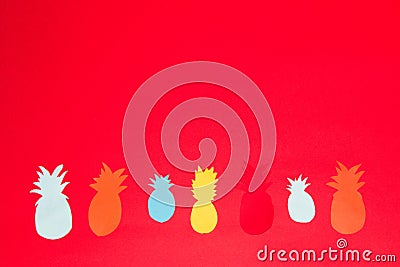 colorful pineapples at the bottom of a red background, creative healthy design, paper pineapple Stock Photo