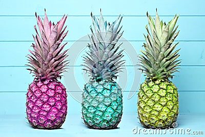 Colorful pineapples on a pastel blue wood background Stock Photo