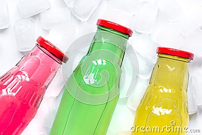 Colorful plastic bottles with ice cubes white desk background top view mockup Stock Photo