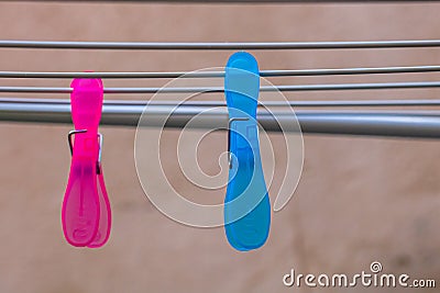 Colorful plastic clothes pegs on empty metal clothes dryer Stock Photo