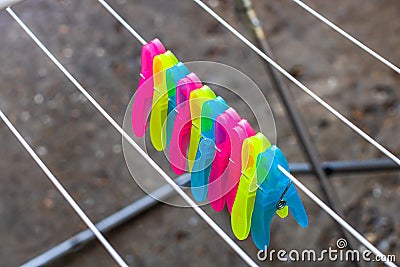 Colorful plastic clothes pegs on empty metal clothes dryer Stock Photo