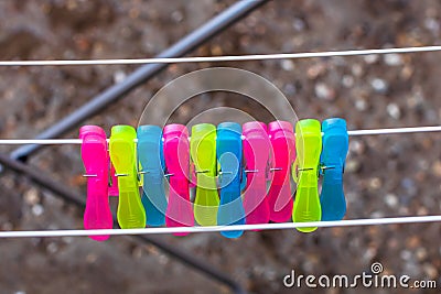 Colorful plastic clothes pegs on empty metal clothes dryer Stock Photo