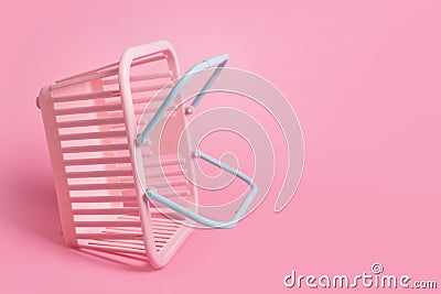 Colorful plastic shopping baskets. Empty pink and blue supermarket basket on pink pastel background. Creative minimalist Stock Photo