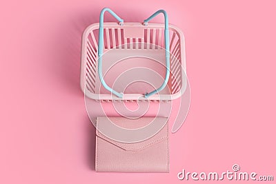 Colorful plastic shopping baskets with leather wallet. Empty pink and blue supermarket basket on pink pastel background Stock Photo