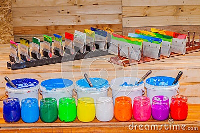 Colorful of Plastisol Ink in the clear glass can on the pinewood table for screen print tee shirt. Stock Photo