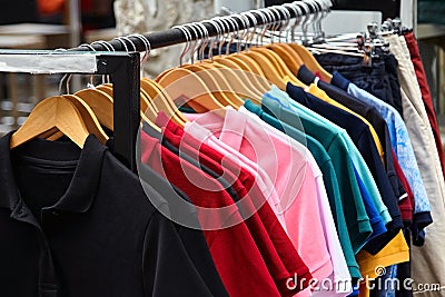 Colorful polo t-shirt for man on wooden hangers in a retail shop Stock Photo