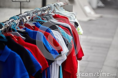 Colorful polo t-shirts for the man on hangers in a store. Street sale of male clothes Stock Photo