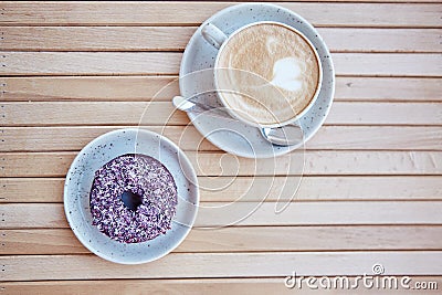 Colorful purple doughnut and cappuccino at the terrace in the cafe. Aesthetic coffee time. Top view, copy space on Stock Photo