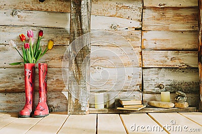 Colorful rain boots with spring flowers,candles , stones and boo Stock Photo