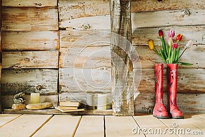 Colorful rain boots with spring flowers,candles , stones and boo Stock Photo