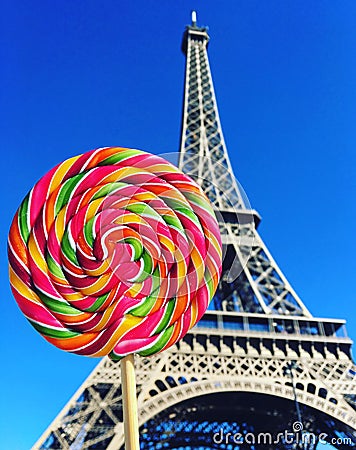 Colorful rainbow lollipop swirl on wooden stick on Eiffel Tower background Stock Photo