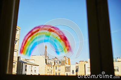 Colorful rainbow painted on window glass in Parisian apartment, Eiffel tower is seen in the background Stock Photo