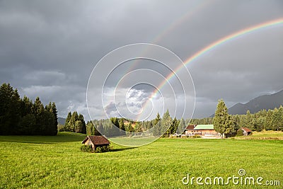 Colorful rainbow during rain in Alps Stock Photo