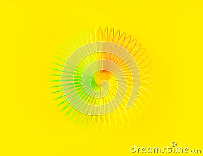 Colorful rainbow spiral plastic toy on yellow background Editorial Stock Photo