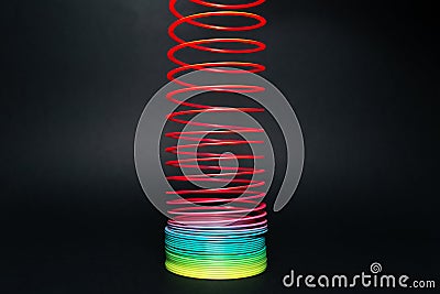 Colorful rainbow spiral toy on black background. Editorial Stock Photo