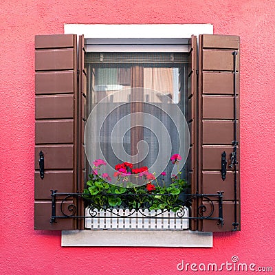 Colorful residential window with blooming flowers in Burano Stock Photo