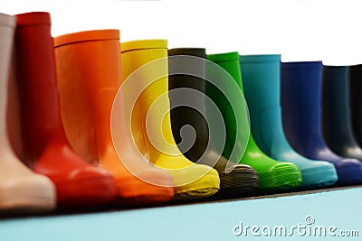 Colorful rubber rain boots for kids on the shelf of a store, waterproof footwear for fall Stock Photo