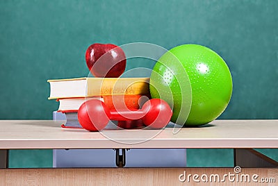 Colorful school accessories (apple, books, ball) on table Stock Photo