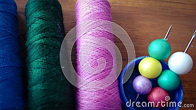 Colorful sewing threads with colorful bubbles on wood background Stock Photo