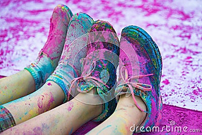 The colorful shoes and legs of teenagers with purple color powder in the public event The Color Run Stock Photo