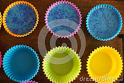 Colorful silicon cupcake molds on wooden coard filled with liquid soap for a home made hobby of melt and pour soapmaking Stock Photo