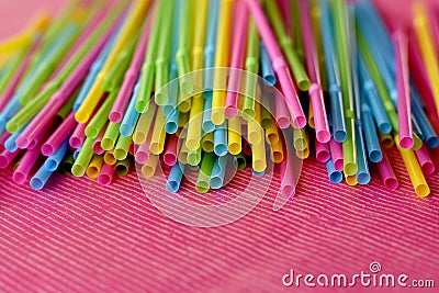 Colorful single use disposable plastic straws on pink surface Stock Photo