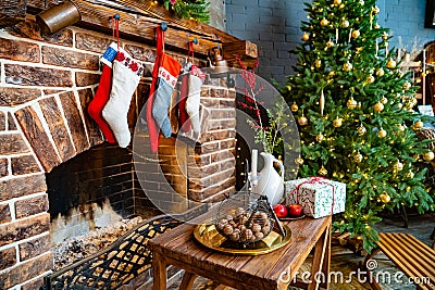 socks for a gift from Santa Claus hang on the fireplace. a large christmas tree Stock Photo