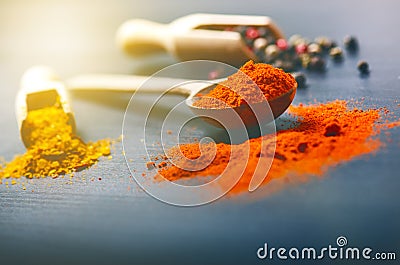 Colorful spices on a dark blue table. Concept of kitchen and cooking. Spicy on a wooden spoon. Stock Photo