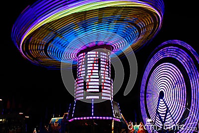 Colorful Spinning Swings, Ferris Wheel at Night Stock Photo