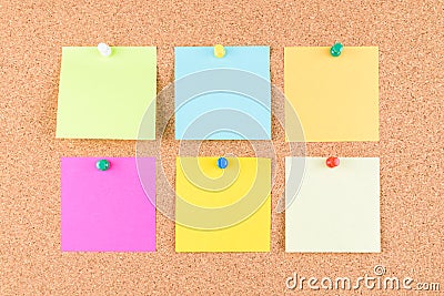 Colorful sticky note on brown cork board with colorful tack pin or Thumbtack or pushpin Stock Photo