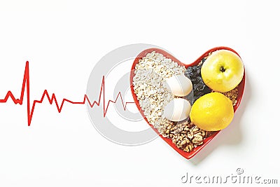 Colorful still life of a bowl of fresh fruit with a red heart beside it Stock Photo