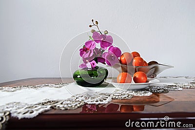 Colorful still life of a pink orchid flower in a green vase and Stock Photo
